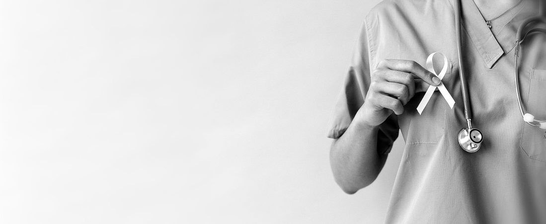 black and white photo of person in medical scrubs with a stethescope and an advocacy ribbon