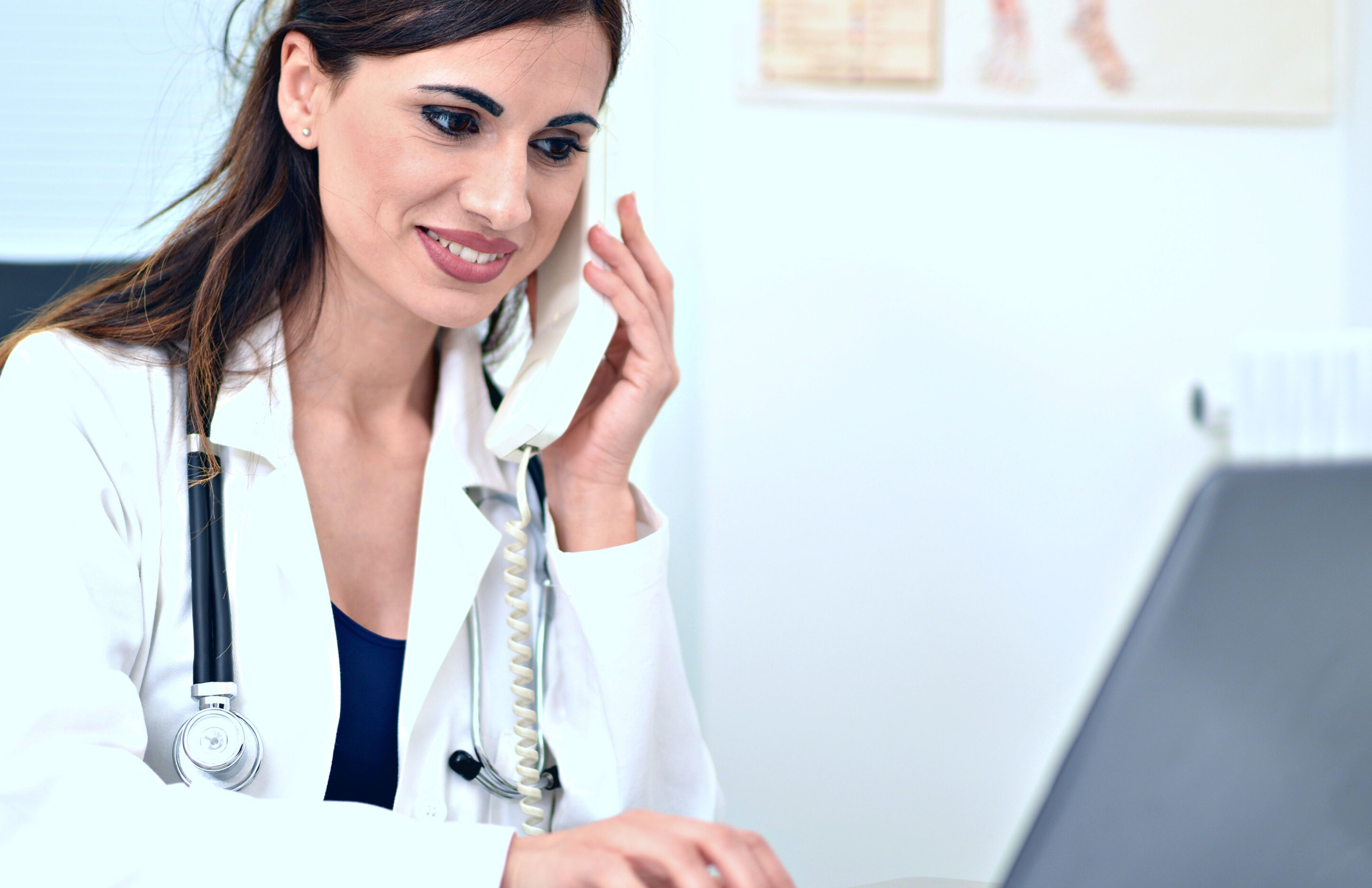 doctor on the phone facing a computer