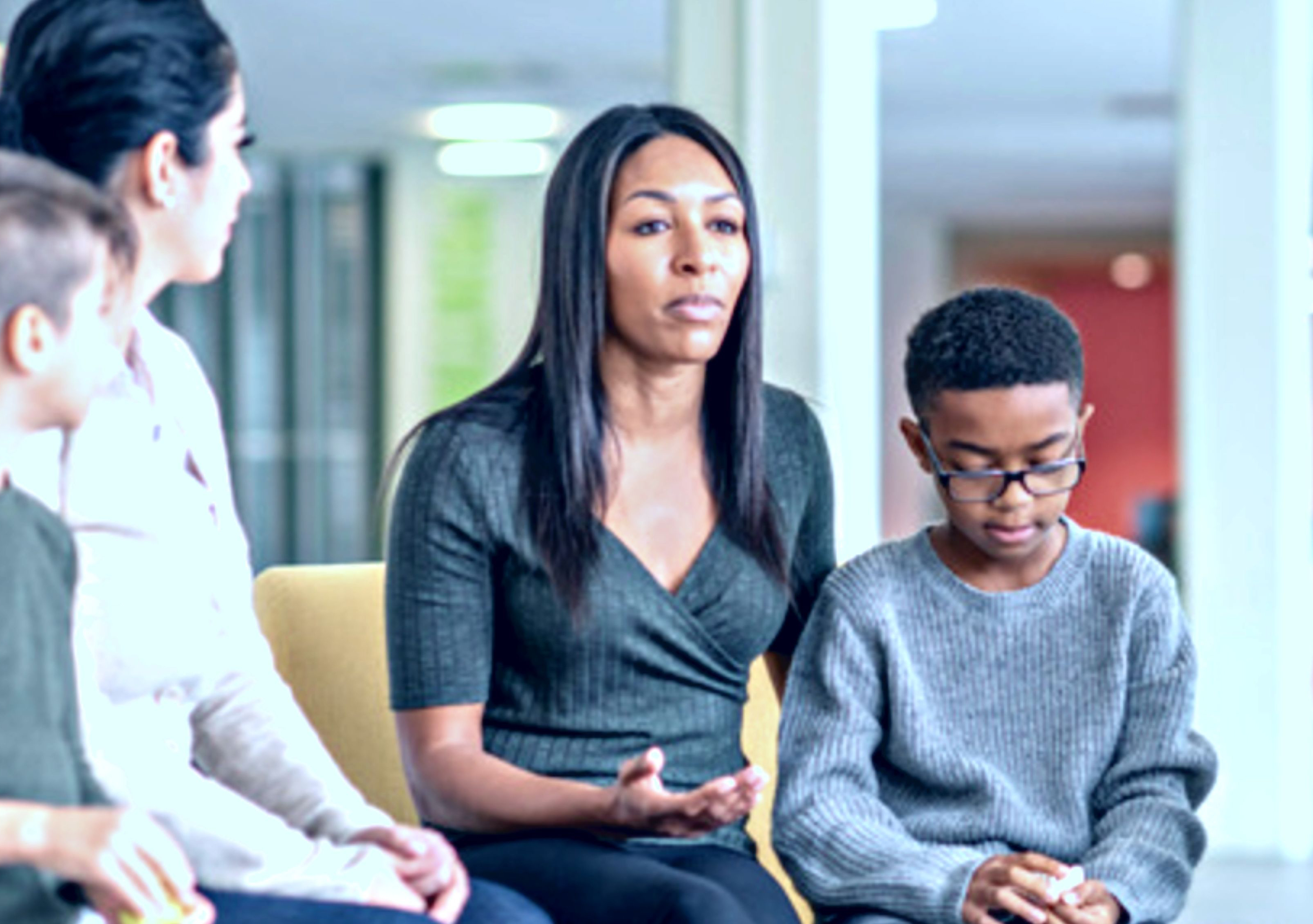 parents sitting with their younger teen-aged children in a circle talking